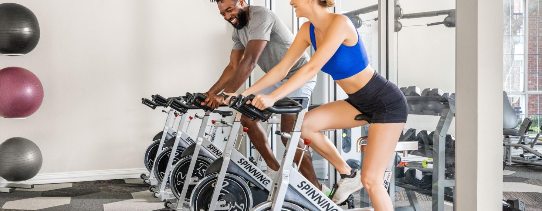 a man and a woman working out on a bike